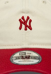 Ρυθμιζόμενο καπέλο με κρεμ χρώμα στην κορυφή και κόκκινο γείσο, με ανάγλυφο κόκκινο κεντητό λογότυπο "Yankees" και στρογγυλή μαύρη ετικέτα New Era με την ένδειξη "9TWENTY".
