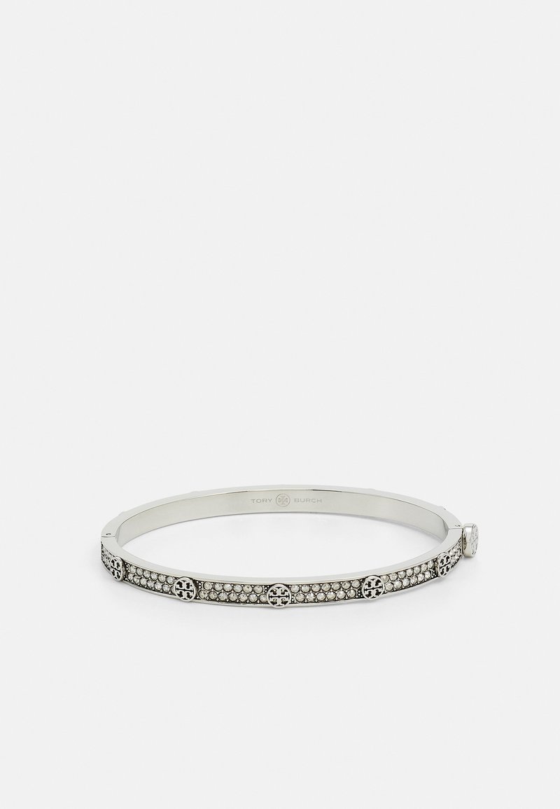 Sidabrinė metalinė apyrankė su apvaliais akcentais ir įmontuotais skaidriais kristalais, lygiu paviršiumi ir geometrine forma.