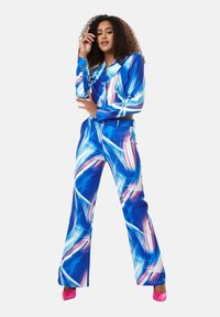 Blue and white patterned matching outfit with long sleeves and flared pants. Highlights include pink accents and a glossy fabric texture.