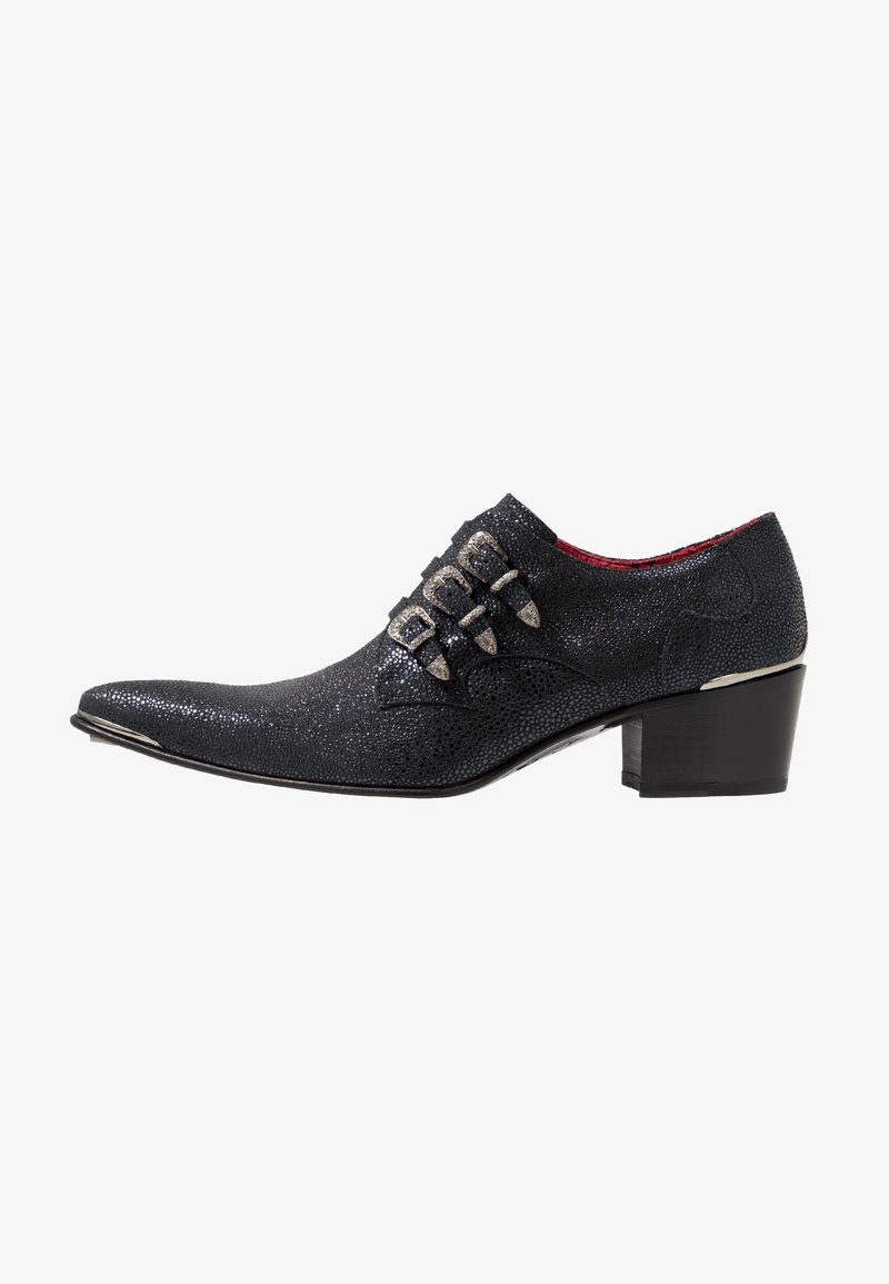 Chaussure habillée en cuir noir texturé avec bout pointu, trois boucles argentées sur le côté et petit talon bloc avec doublure intérieure rouge.