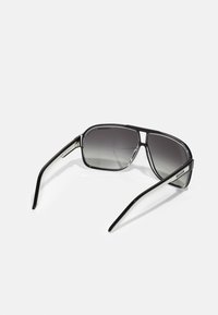 Ochelari de soare cu un cadru din plastic negru, formă rectangulară și lentile gri cu degradé. Prezintă brațe subțiri negre cu accente argintii.