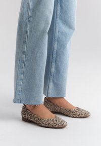 Ballerine con stampa leopardata, con punta rotonda, tessuto morbido e tacco basso, abbinate a jeans a gamba larga light blue con orlo sfilacciato.