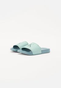 Helle grüne Rutschsandalen mit einem glatten Obermaterial aus Synthetik, offenem Zehendesign und einer strukturierten Sohle für besseren Halt. Verstärkte Nähte als Akzent.
