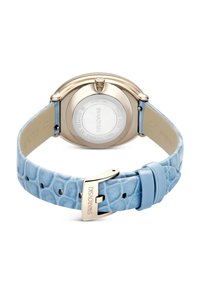 Orologio rotondo con cassa in acciaio inossidabile e cinturino in pelle azzurra chiaro, con texture. Presenta una fibbia dorata e marchio inciso sul cinturino.
