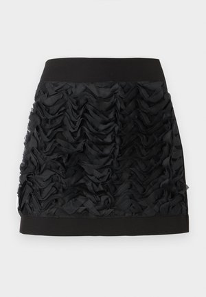 Jupe noire mini avec un devant en chiffon à volants, dotée d'une taille lisse noire. Les volants créent de la texture et du mouvement.