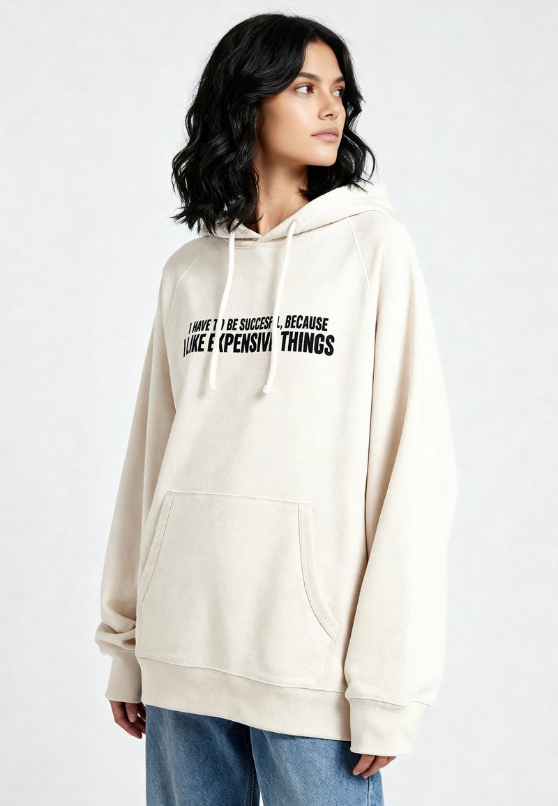 Felpa con cappuccio color crema realizzata in tessuto morbido, con tasca a marsupio e stampa nera. Maniche lunghe e vestibilità comoda con polsini a costine.
