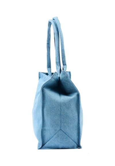 Borsa tote in denim azzurro chiaro con manici lunghi mostrata di profilo su sfondo bianco.