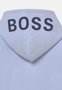 Lichtblauwe hooded sweatshirt met een gladde textuur; heeft opvallende zwarte "BOSS" letters over de achterkant.