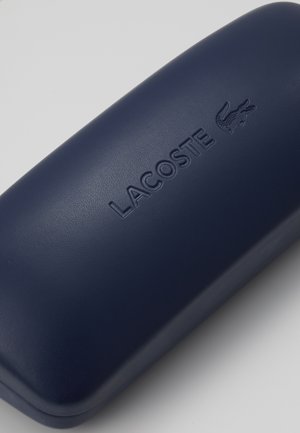 Custodia rigida blu navy con finitura testurizzata, caratterizzata da un logo "LACOSTE" in debossing e un emblema di coccodrillo sulla superficie superiore.