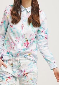 Bloemige button-up shirt van lichtgewicht stof, met een mix van roze, turquoise en witte kleuren, voorzien van een kraag en lange mouwen.