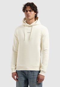 Crème hoodie van zachte stof, met een voorzak in kangoeroestijl, een trekkoordcapuchon en "PURE PATH" in zwart gedrukt op de borst.