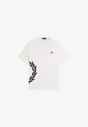 T-shirt blanc à manches courtes avec col rond, petit logo couronne noir sur la poitrine et grand motif partiel de couronne noire en bas à gauche.