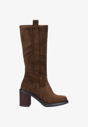 Bota de ante marrón hasta la rodilla con punta cuadrada, tacón bloque y detalles de costura lateral. Presenta una lengüeta para facilitar su puesta.