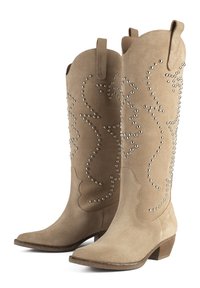 Beige suede cowboy boots featuring a pointed toe, stacked heel, and silver studded embellishments in a swirling pattern along the shaft.