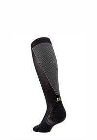 Calza compressiva nera fino al ginocchio con un motivo grigio testurizzato, dotata di punta e tallone rinforzati con accenti riflettenti gialli.