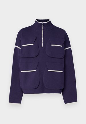 Lilla kootud pullover, millel on kõrge krae, pool tõmblukk ja neli esist kotti valge äärega. Sujuv tekstuur ja struktureeritud disain.