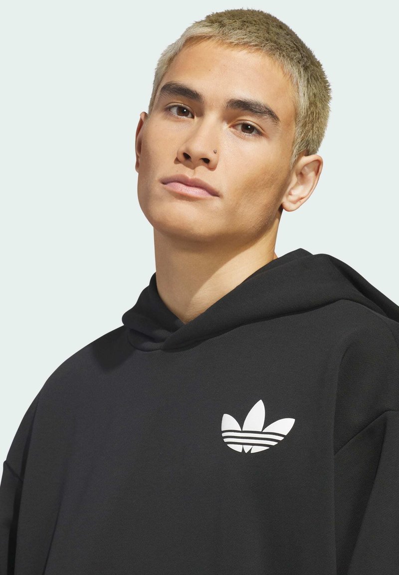Zwarte hoodie gemaakt van stof met een gladde textuur, voorzien van een wit Adidas-logo op de borst en een capuchon met trekkoord.