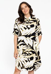 Schwarzes und weißes Hemdkleid mit gelbem tropischem Blattmuster; besitzt einen Kragen, kurze Ärmel und eine durchgehende Knopfleiste; leichtes Material.
