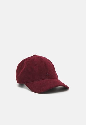 Cappello in corduroy bordeaux con visiera curvata e un piccolo logo ricamato in rosso, bianco e blu sul pannello frontale sinistro.