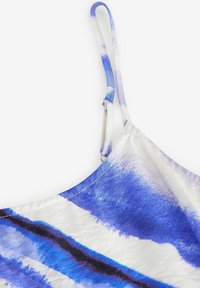 Top in raso a righe blu e bianche con spalline regolabili, texture liscia e scollatura arrotondata nell'angolo in alto a sinistra.