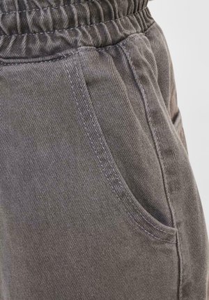 Gray cotton pants with a brushed texture, featuring an elastic waistband and side pockets, highlighted by visible stitching details.