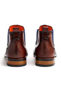 Braune Leder-Stiefeletten mit blauem Textilobermaterial, strukturierter Oberfläche, kontrastierendem orangefarbenem Futter und gestapeltem Holzabsatz mit schwarzem Akzent.