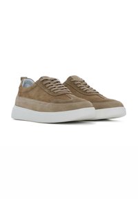 Tan suède sneakers met witte rubberen zolen, voorzien van veters, een ronde neus en gestikte details langs de zijkanten.
