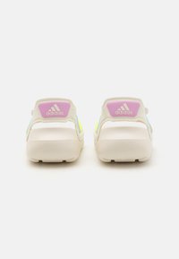 Adidas fottøy med en beige base, livlige detaljer i rosa, gul og blå, med en teksturert såle og baklogo.