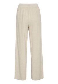 Pantaloni bej deschis, cu croială largă, având un elastic la talie, fabricați dintr-un material texturat. Fără buzunare sau embellismente vizibile.