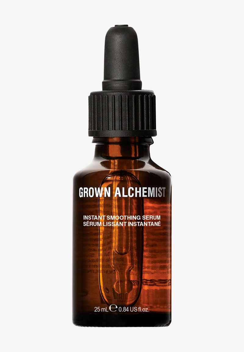Amber glazen pipetfles met een zwarte schroefdop, waarop witte tekst staat met de labeling "GROWN ALCHEMIST" en "INSTANT SMOOTHING SERUM." 25 mL.