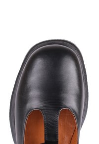 Chaussure à enfiler en cuir noir avec bout arrondi et intérieur marron contrastant, vue de dessus sur un fond blanc.