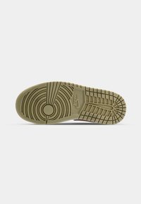 Nike sneaker outsole, featuring a rubber sole in olive green with circular and linear tread patterns, including the Nike logo.