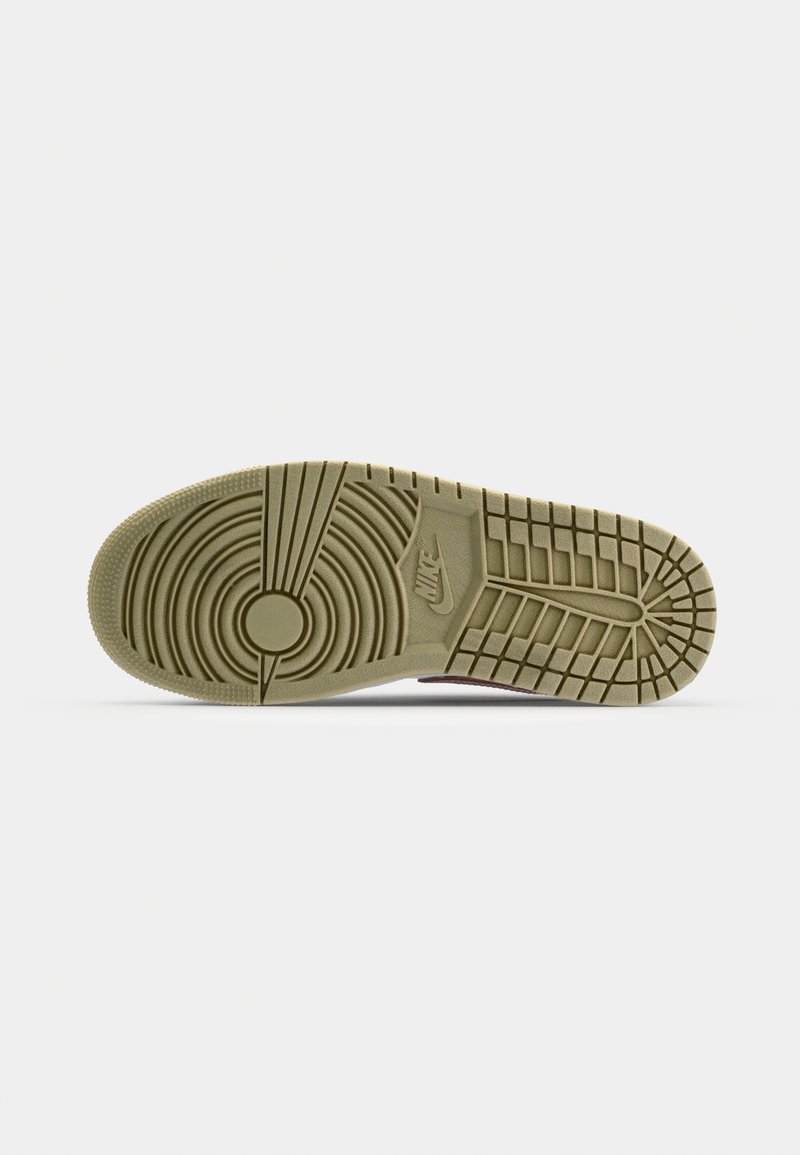 Semelle de sneaker Nike, avec une semelle en caoutchouc olive composée de motifs de traction circulaires et linéaires, incluant le logo Nike.