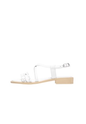 Hvide sandaler lavet af syntetisk læder med en lav blokhæl, der har to stropper og et mønstret accent på den forreste strop. Justerbar ankelrem.