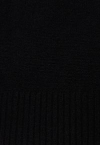 Schwarzer Strickpullover aus Stoff mit einer glatten Textur und gerippten Details am unteren Saum. Gleichmäßige und homogene Farbe über das gesamte Stück.