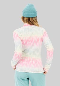 Langarm, lichte fleece-top met een pastel tie-dye patroon in roze, blauw en groen; heeft een hoge kraag en aansluitende mouwen.