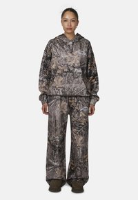 Felpa con motivo camouflage e pantaloni a gamba larga in tonalità di marrone e grigio, con una tasca frontale e una vestibilità ampia per il massimo comfort.