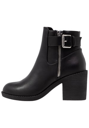 Bottine noire en cuir avec talon bloc, fermeture éclair latérale et détail de sangle réglable à boucle.