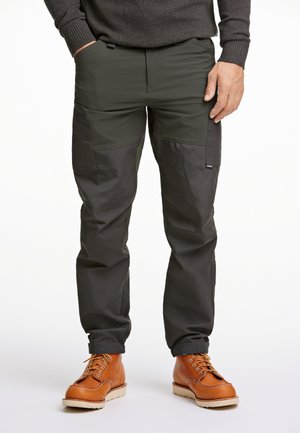 Cargo pants in dark green and black with a relaxed fit, featuring multiple pockets and a lightweight, durable fabric texture. Brown leather boots.