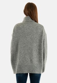 Pull en maille gris surdimensionné avec un col montant. Présente des poignets et un ourlet côtelés, une texture douce et une coupe décontractée. Vue de dos montrée.