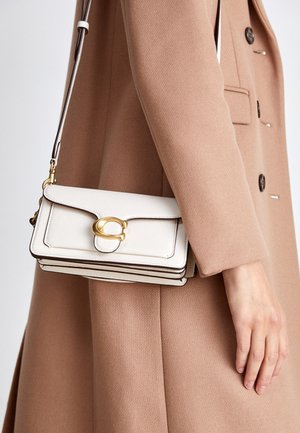Geantă de umăr albă din piele, cu un închizător aurie, având un design structurat, margini contrastante și o curea subțire ajustabilă.