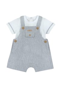 Salopette rayée grise avec boutons en bois, poche avant et jambes courtes, associée à une chemise blanche à manches courtes avec des accents gris.