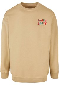Bež kampsärkk, millel on pikad varrukad, soonikuga mansetid ja alläär, esiküljel vasakul pool on värvikas "holly jolly" tekstidisain.