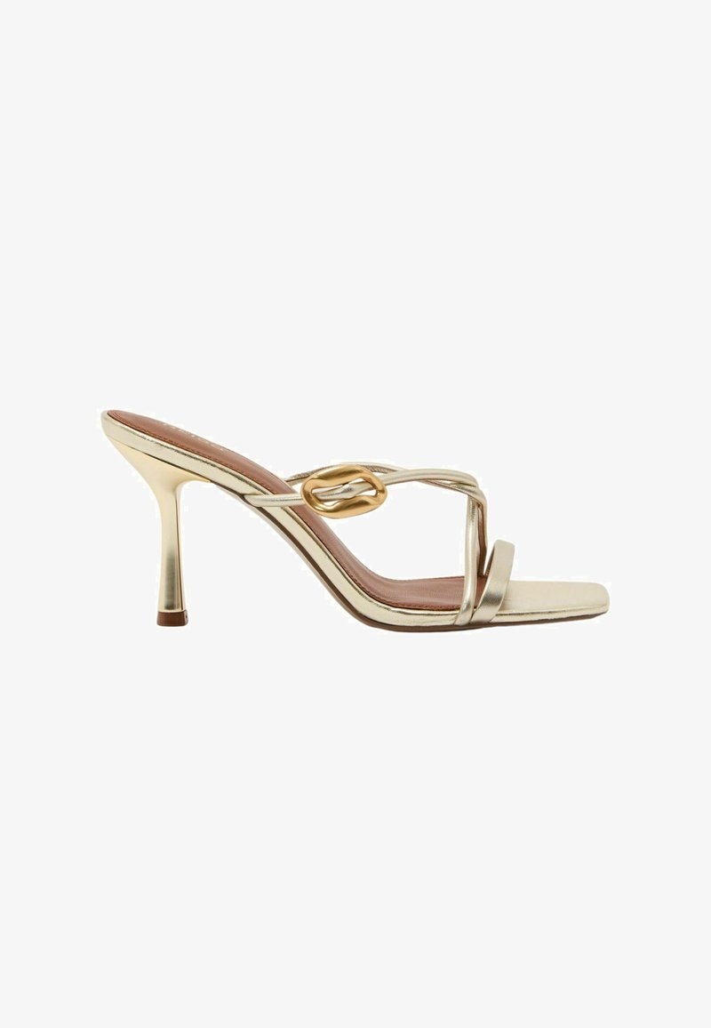 Arany magas sarkú szandál vékony pántokkal, négyzet alakú orral és dekoratív aranycsattal az oldalpánton.