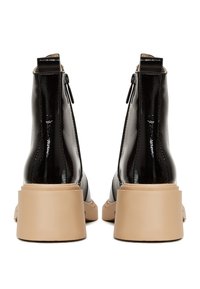 Stivaletti neri in pelle verniciata con punta quadrata, chiusura con zip e tacco chunky beige, caratterizzati da una finitura liscia e lucida.