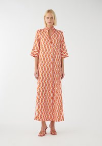 Langes Maxikleid aus einem leichten Stoff mit einem lebendigen orange-weißen Grafikmuster. Es hat einen Kragen und Glockenärmel.