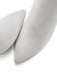 Graue Wildleder-Pumps mit spitzem Zehenbereich, die über eine glatte Textur und ein elegantes Design verfügen. Sie bieten eine schlanke Silhouette ohne sichtbare Beschläge oder Muster.