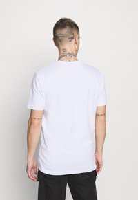 White cotton t-shirt with a round neckline and short sleeves, featuring a plain design and a straight hem at the waist.