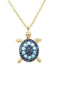 Ciondolo a forma di tartaruga in oro con un guscio ovale, decorato con pietre turchesi e blu scuro, e pinne testurizzate, appeso a una catena d'oro.