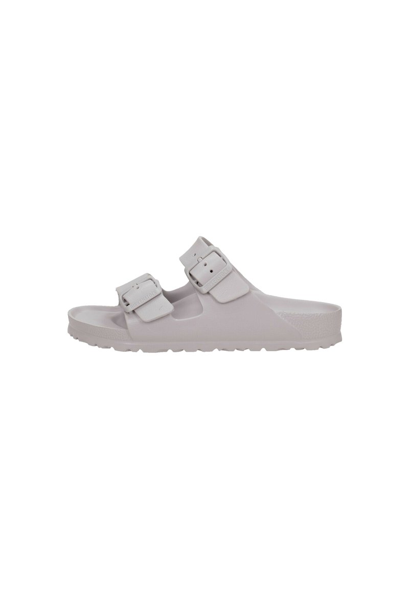 Sandales gris clair en matériau lisse avec deux sangles réglables et boucles. La semelle présente un motif texturé pour une meilleure adhérence.